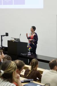 Eine Frau spricht an einem Rednerpult zum Publikum.