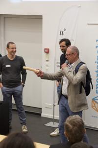 Ein Mann hält einen Staffettenstab in der Hand und übergibt diesen an seinen Nachfolger.